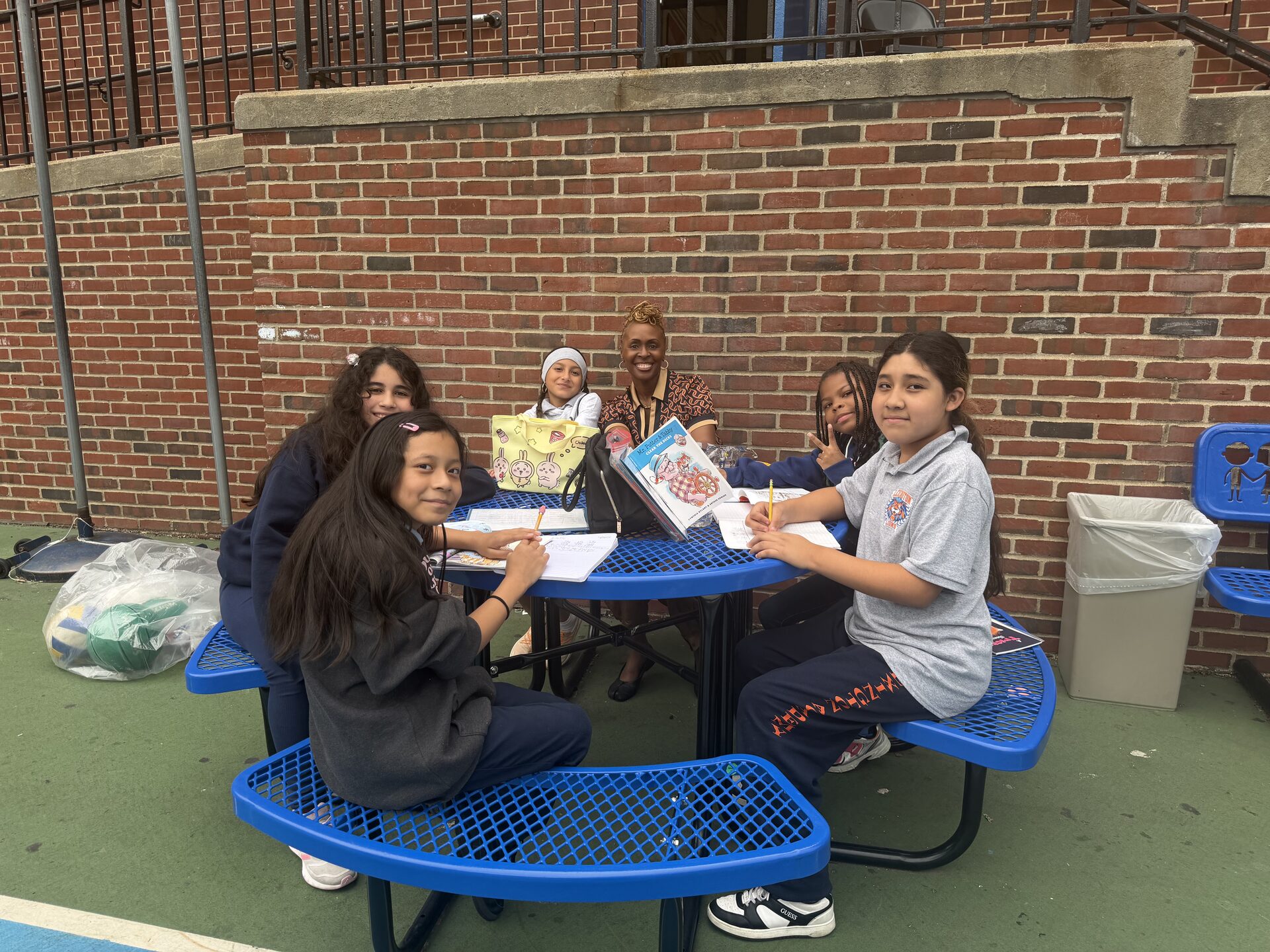The Lexington Academy — Our 5th grade girls reading and writing with Dr. Smith at a picnic table in the schoolyard